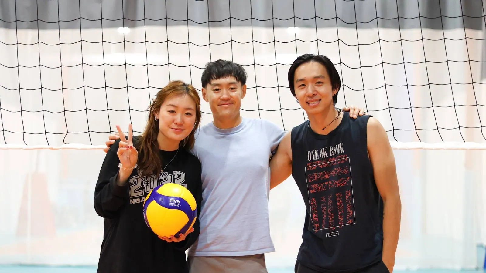 Three friends posing together in front of the net after a game