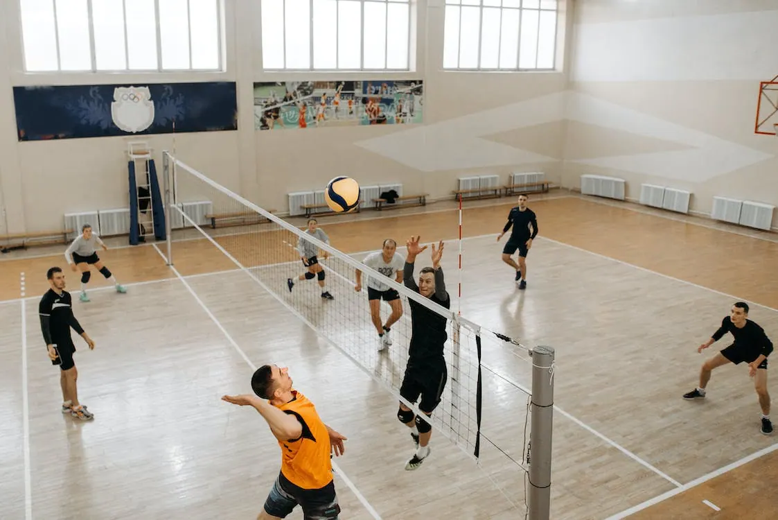 Free Player Jumping near Net with Arms Raised Stock Photo