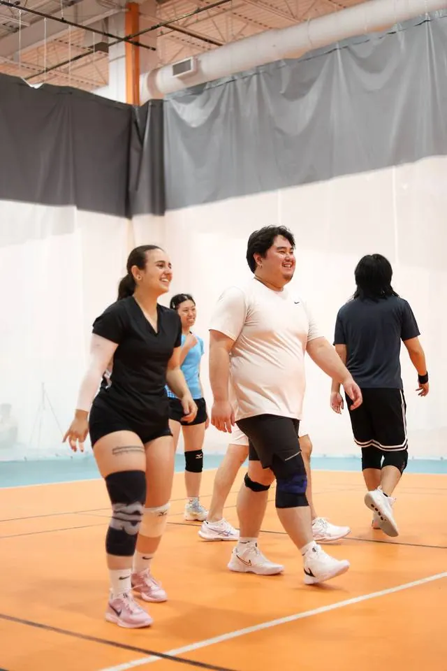 Drop in players laughing as they walk onto the court
