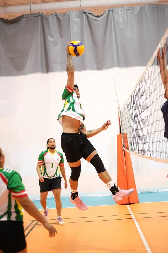A player rising for a spike above the net